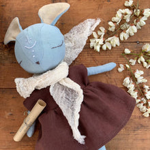 Charger l'image dans la galerie, Handmade blue linen mouse spirit guardian doll dressed in a plum dress with a gauzy scarf, displayed on a wooden background with delicate acacia flowers
