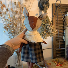 Charger l'image dans la galerie, Handmade linen fox spirit guardian doll with embroidered details, dressed in a dark plaid skirt and creamy muslin scarf, surrounded by dried herbs and natural botanical elements.